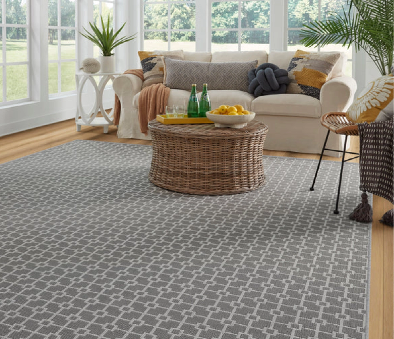 Overhead view of a light blue geometric woven rug next to a round wooden table.