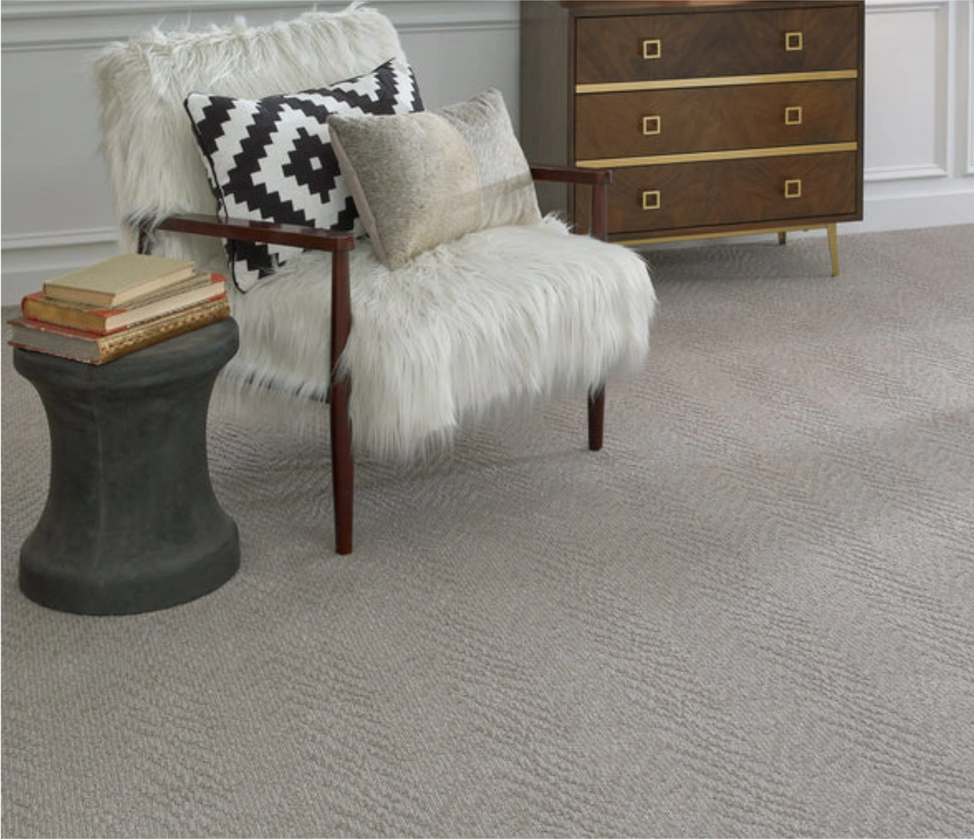 Light grey textured wall-to-wall carpet in a living room next to a white furry armchair.